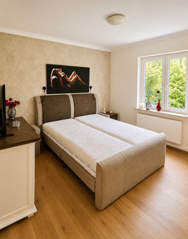 Schlafzimmer mit Doppelbett und Fenster zum Garten