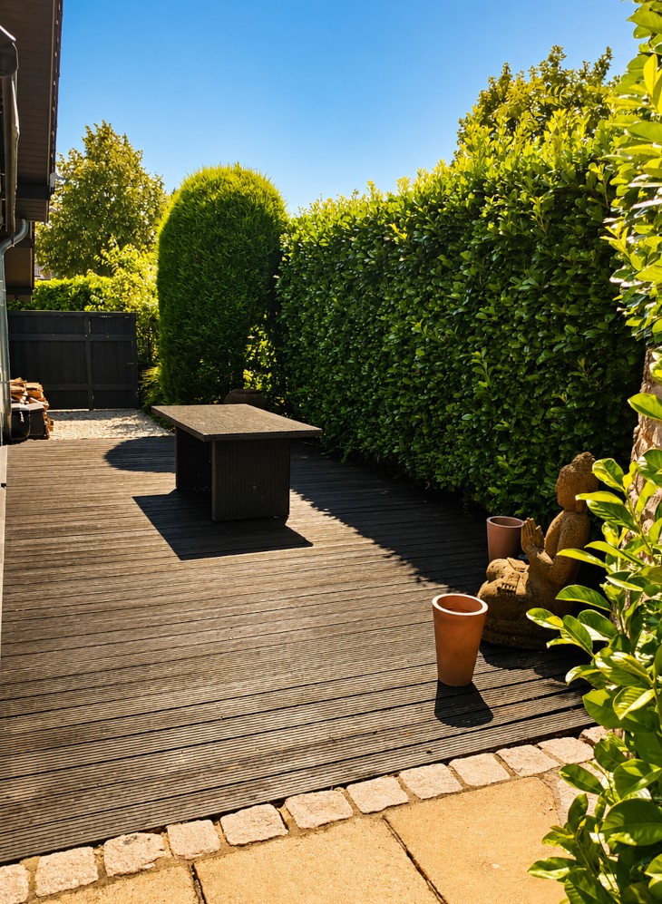 Holzterrasse mit Sichtschutzhecke